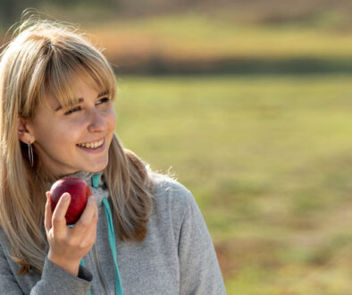 smiling-blonde-woman-eating-delicious-apple