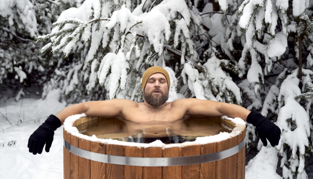 Caucasian man take the winter bath in tube outdoors in forest