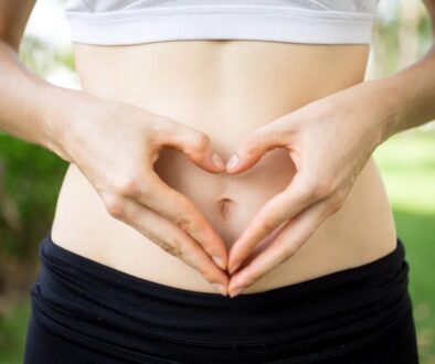 close-up-female-hands-shaping-heart-belly