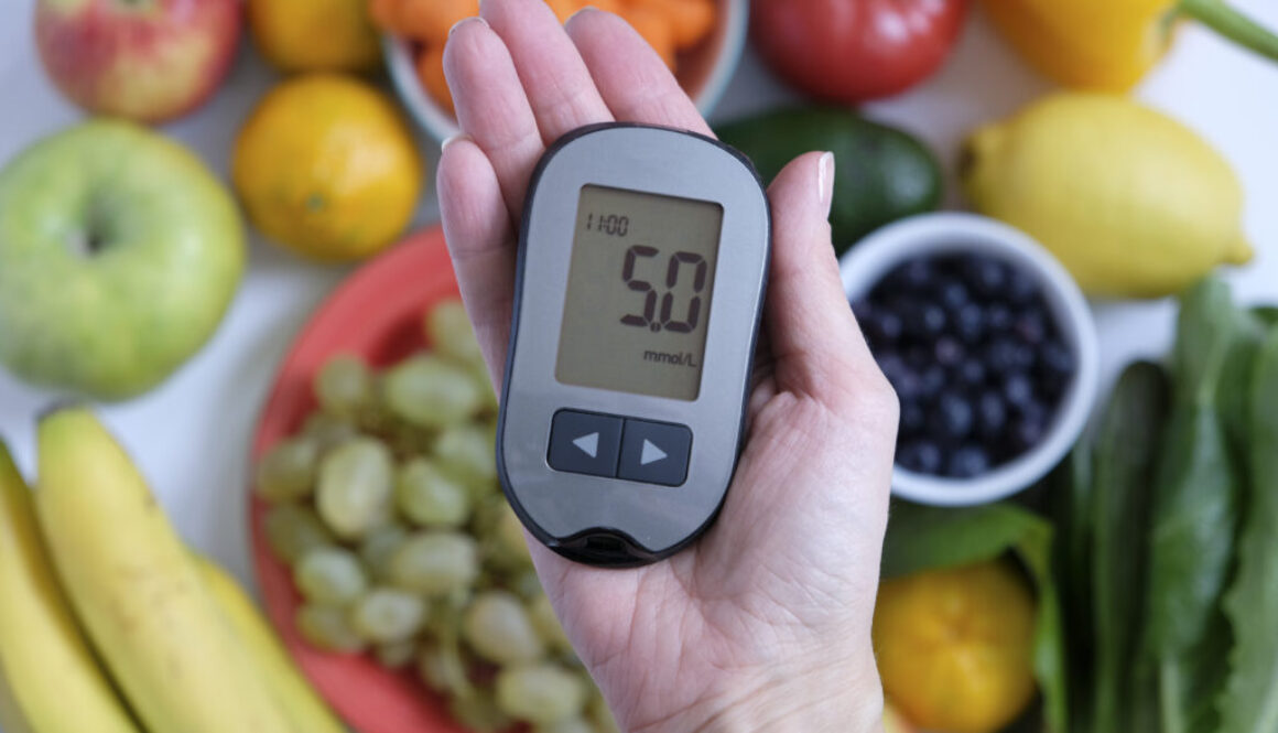 Diabetes concept: glucometer in hand and healthy food. Nutrition cause diabetic desease hladina cukru v krvi