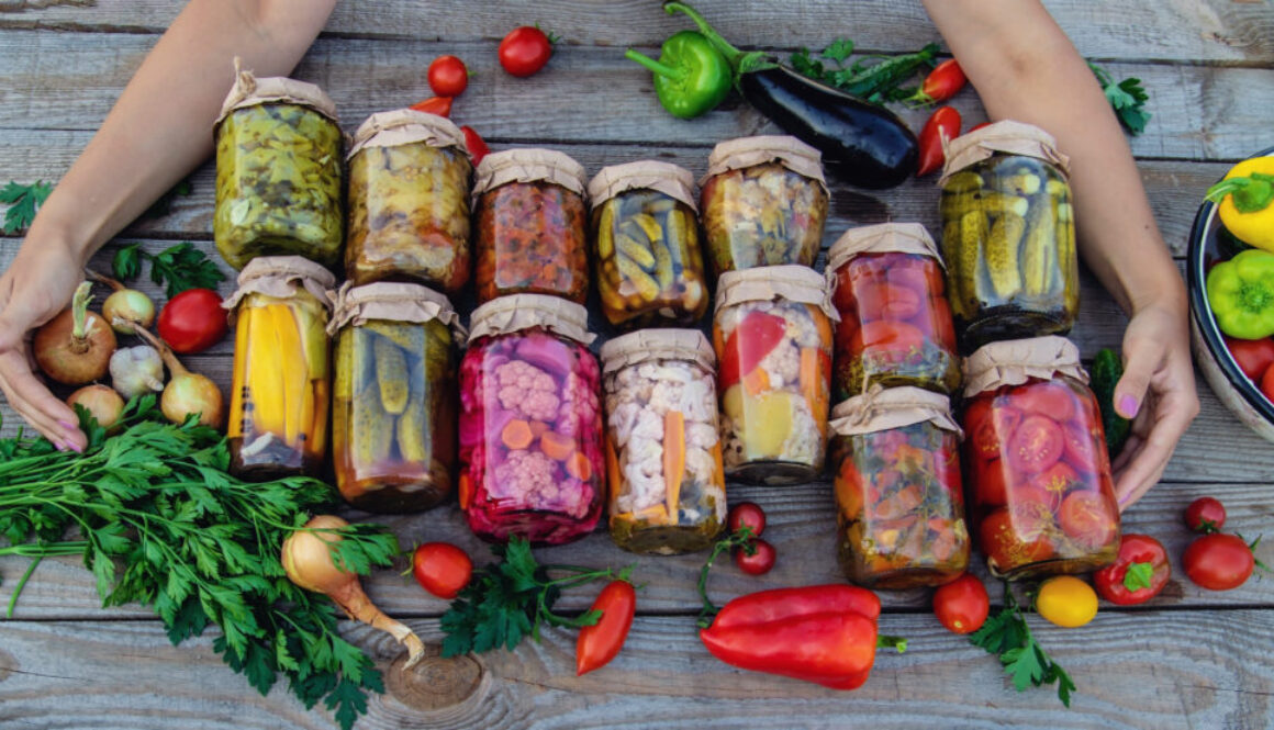 Woman canning vegetables in jars on the background of nature. preparations for the winter fermentované