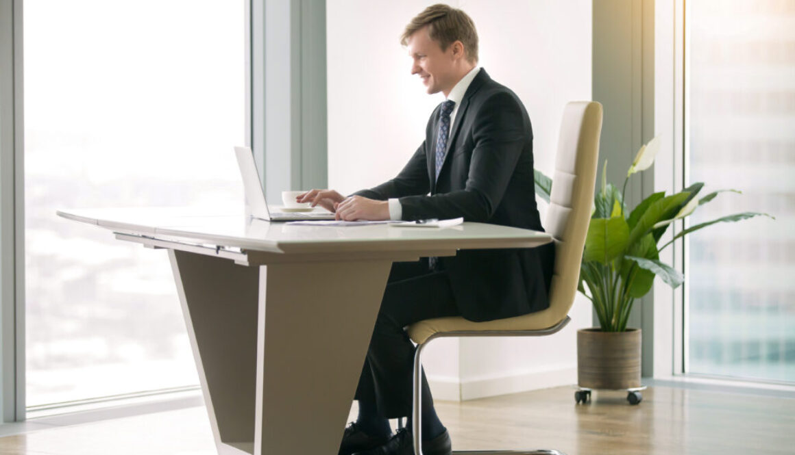 Businessman working with laptop at the moderm desk sedenie