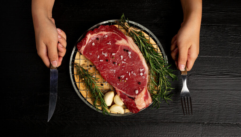 fresh raw beef steak on the dark background.