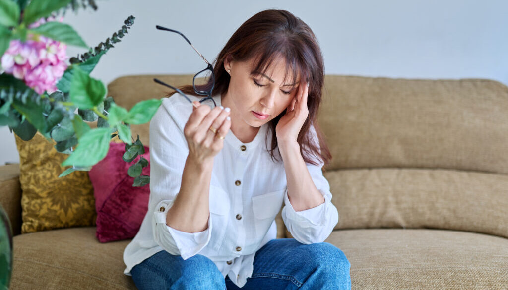 Middle-aged woman experiencing stress, difficulties, headache